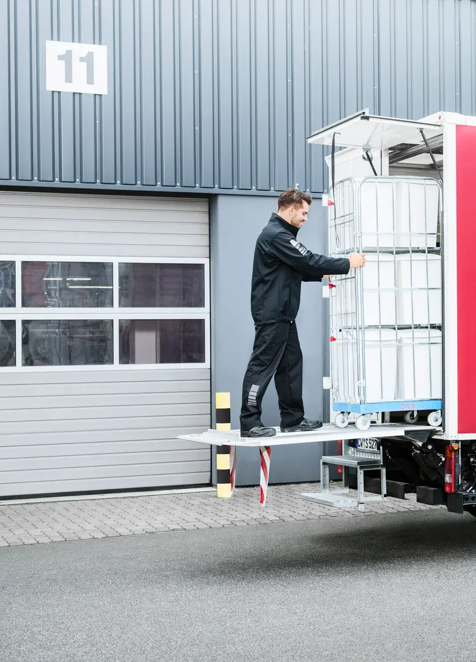 A male CWS service driver loads his truck with clean CWS Hygiene Bins