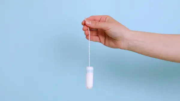 Can you flush tampons? Woman holding tampon