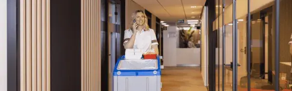 Cleaning lady servicing disinfectant dispensers 